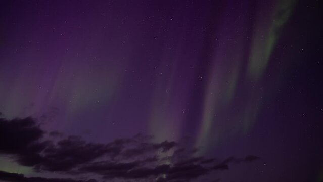 Aurora borealis sprites behind clouds on stars