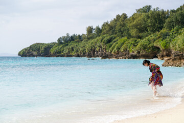 沖縄のビーチを歩く女性2