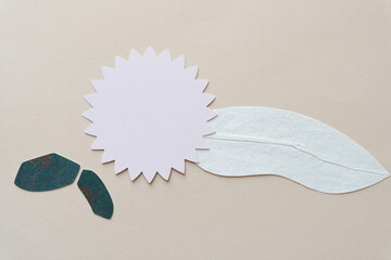 stylized or abstract representation of a flower or floral emblem or badge with spoke-like edges or...