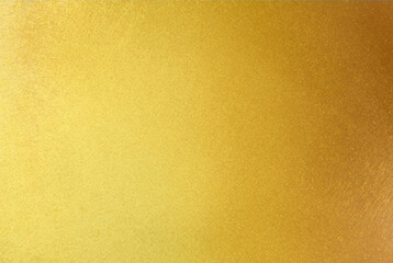 Shiny gold foil polished background with the reflection of golden light.