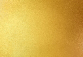 Shiny gold foil polished background with the reflection of golden light.