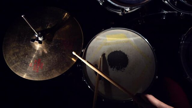 Top view of hands of rock musician drummer playing hitting drums and cymbals.