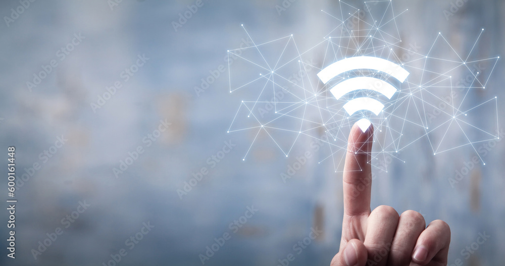 Wall mural male hand showing wireless technology symbol. wifi symbol with a network connection