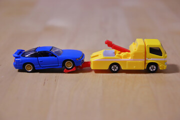 Fototapeta premium レッカーされる青いミニカー