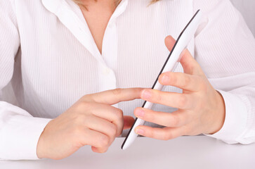 Woman's hands holding tablet computer on white background.