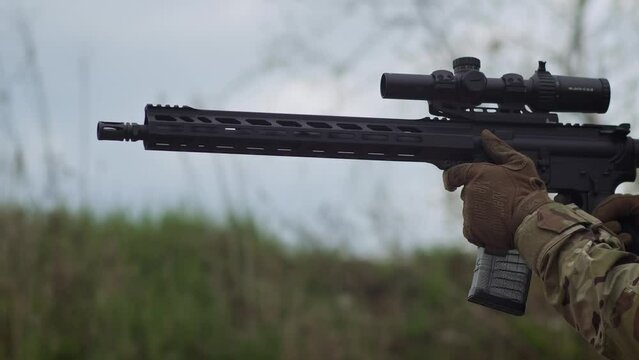 a man shoots a carbine at a target in slow motion