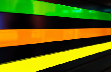 Black ribbed wall with multi-colored neon stripes.