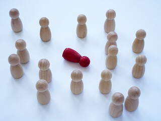 Bystander effect concept. Wooden figurines and in the middle lies a red one.