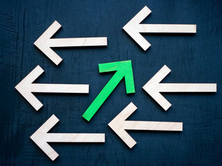 Be unique and different abstract. Wooden arrows in one direction and green in the other.