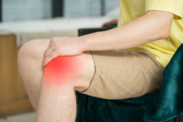 Obraz premium Knee pain, man suffering from ache and doing self-massage at home, self-soothing massaging