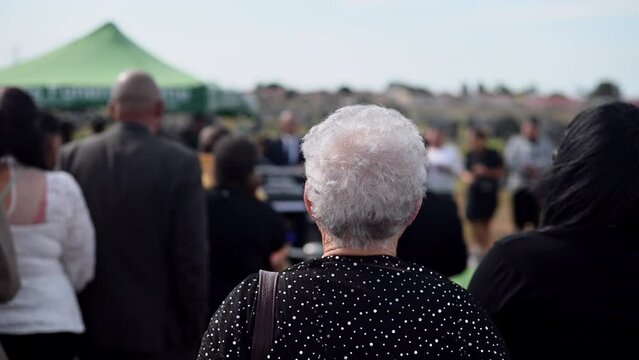 Rear view of mature woman at funeral service