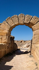 Stone arch over an entrance to the amphitheater in the Roman ruins at Uthina, outside of Tunis, Tunisia