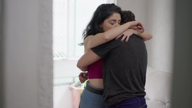 Couple reconciling after fight, candid empathic hug between man and woman. Loving embrace between girlfriend and boyfriend