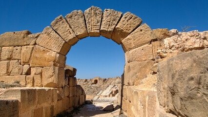 Stone arch over an entrance to the amphitheater in the Roman ruins at Uthina, outside of Tunis, Tunisia