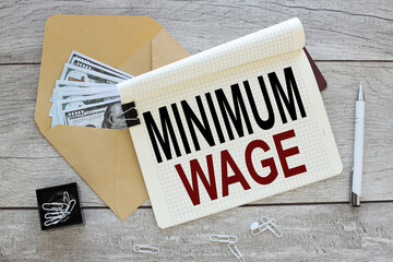 Minimum Wage text on an open notepad. near the envelope with money