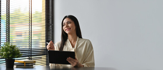Copy space and Empty space for advertisement and text with Smiling of Young Businesswoman working with tablet.