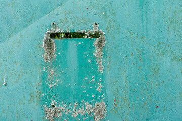 old and damaged turquoise metal door with mailbox opening nostalgia for the old days