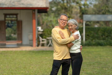 Naklejka premium Elderly couple. Asian couple giving love to each other smiling happily. Happy Asian senior couple in the park