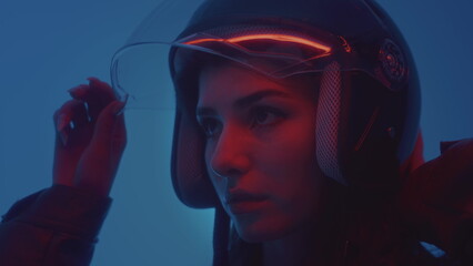 A girl puts on a helmet. A beautiful woman in a leather jacket puts on a helmet for or scooter....