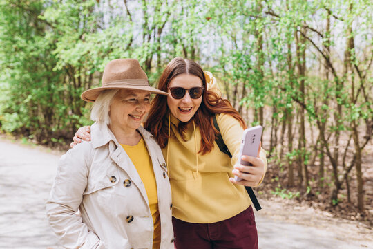 Two women together wear casual clothes doing selfie shot pov on mobile cell phone. Family day concept. Young woman and senior middle aged mom spending time together