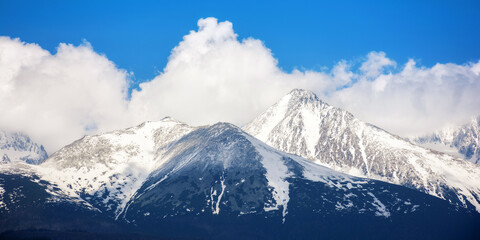 Fototapeta na wymiar background image of high tatra peaks in spring. sunny scenery with clouds
