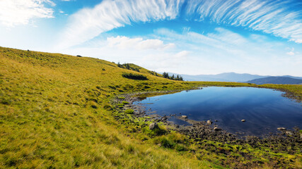 pond in mountains. beautiful countryside landscape of transcarpathia. clouds above horizon on a warm sunny day