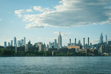 View of the Manhattan skyline and Empire State Building across the East River from Domino Park, Brooklyn, New York
