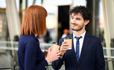 Business partners discussing together outdoor in a modern urban setting during a coffee break