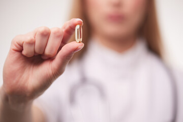 doctor holding a transparent pill in his hands close-up