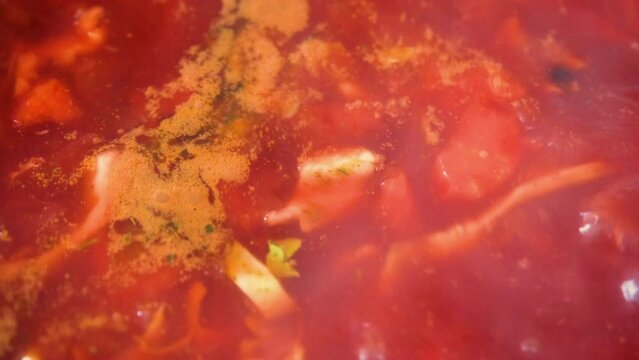 Close up top view on boiling tasty and juicy red borsch or beet soup in saucepan. Cooking food recipe and traditional Ukrainian dish cuisine. Domestic healthy food. 4K resolution food video.