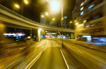 Fototapeta na wymiar Night cityscape of Causeway Bay Downtown in Hong Kong with busy traffic of cars under a highway bridge near Victoria Park (motion blur effect) a captivating glimpse into the vibrant urban experience