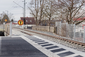 a railway platform and a road sign prohibiting crossing the rails on foot