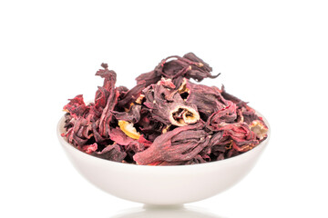 Karkade tea in white ceramic saucer, macro, isolated on white background.