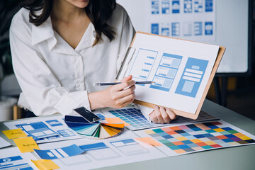 Close up ux developer and ui designer brainstorming about mobile app interface wireframe design on...