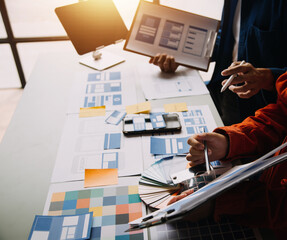 Close up ux developer and ui designer brainstorming about mobile app interface wireframe design on...