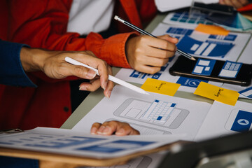 Close up ux developer and ui designer brainstorming about mobile app interface wireframe design on...