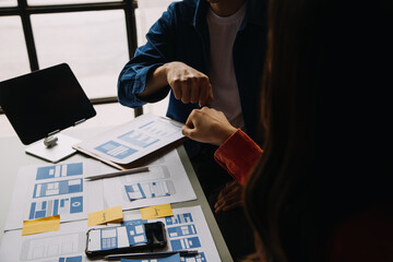 Close up ux developer and ui designer brainstorming about mobile app interface wireframe design on...