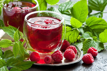 Fresh raspberries  with green leaves and juice in glass
