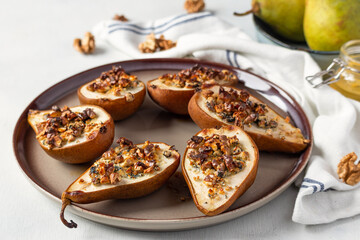 Pears baked with dorblu, gorgonzola, roquefort cheese, honey and walnuts. French cuisine. Roasted pears with cheese.