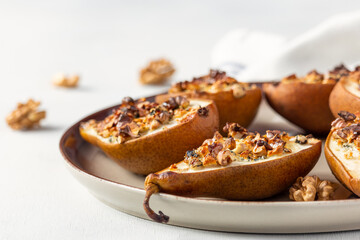 Ready-made dessert of baked pears, dor blue cheese, nuts and honey. Healthy fats, clean eating for weight loss. French cuisine. Roasted pears with cheese.