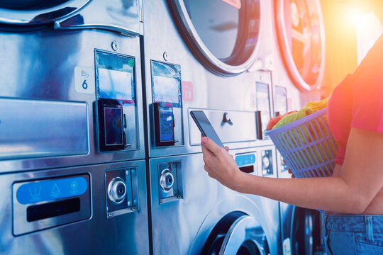 Young woman pays for laundry service using phone and banking application