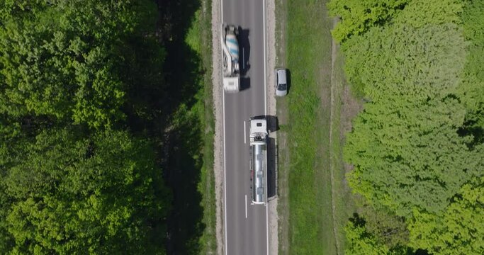 aerial view from drone of moving cistern tank truck on the road in forest