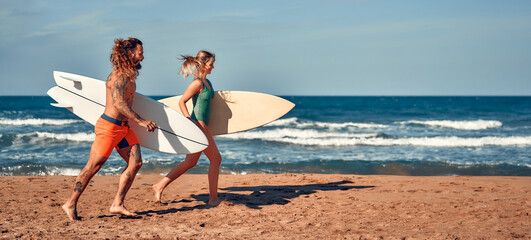 Fototapeta premium Couple of surfers on the beach