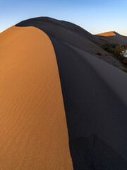 Fototapeta na wymiar Sand dune ridge line with light and shadows