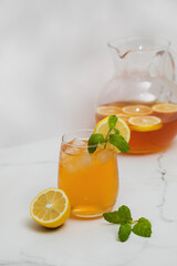 Fototapeta premium Iced tea with lemon and mint in a glass and in a jug. Summer drinks.