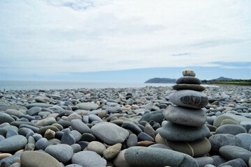 Fototapeta na wymiar Towers made of pebbles. Zen towers on a rocky beach.