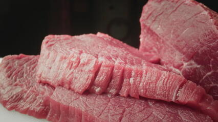 Fresh piece of raw red meat. Close-up macro shot of a fillet texture. Camera on slider along...