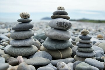 Obraz na płótnie Canvas Towers made of pebbles. Three Zen towers on a rocky beach.