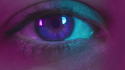 Blue Eye with colorful neon fashion makeup. Young sexy girl in a nightclub. Macro look of the human...