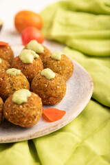 Falafel with guacamole on white concrete. Side view, selective focus.